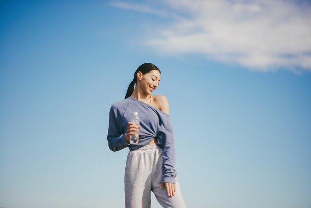 Free Photo cute young woman training with bottle of water
