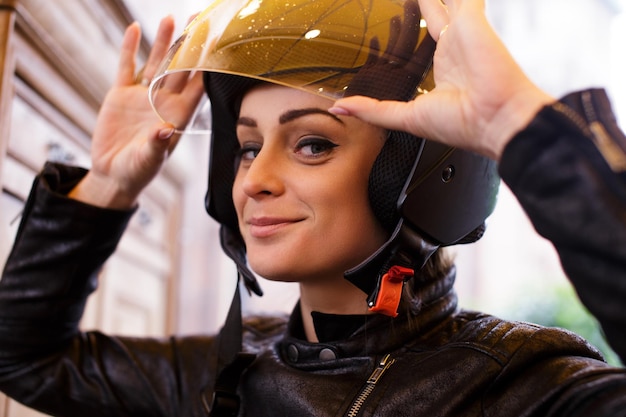 Foto gratuita giovane donna sveglia che indossa un casco da moto.