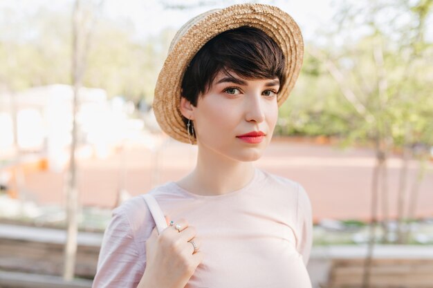 Cute young woman with aristocratic appearance walking in the park before lunch with family