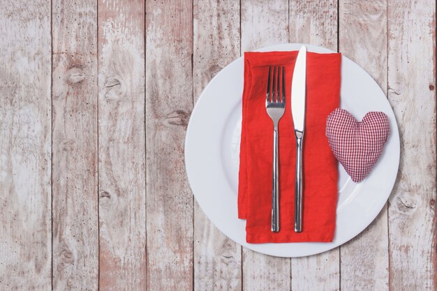 Cutlery on a napkin with a heart next to it