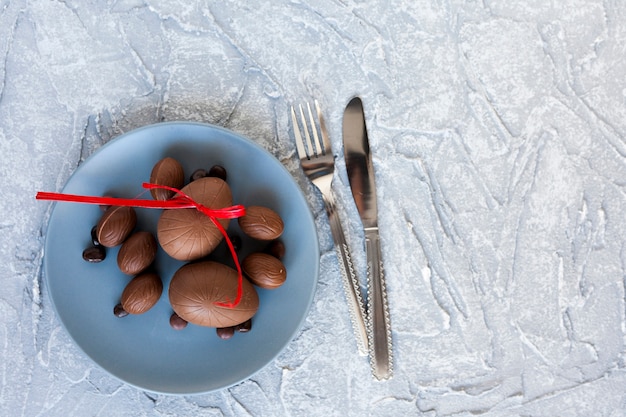 Free photo cutlery near plate with chocolate eggs