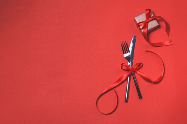 Cutlery tied with a red bow on a red napkin