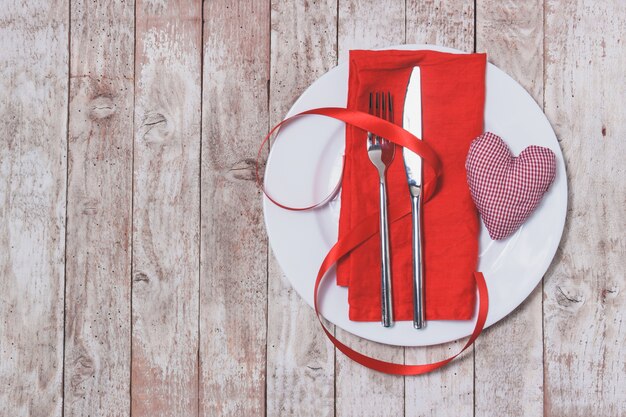 Cutlery tied with a red bow on a red napkin