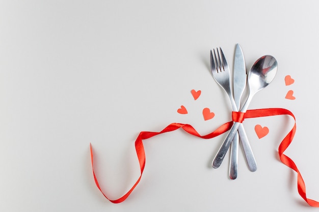 Cutlery with paper hearts on table