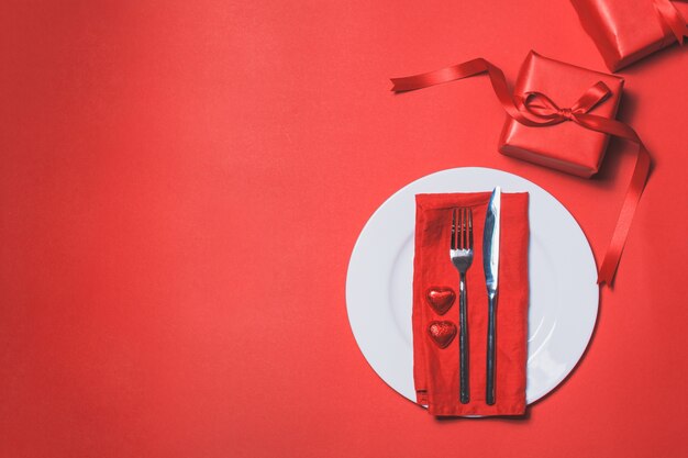 Cutlery with a red gift next to it