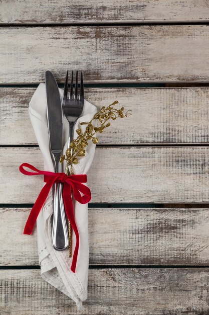 Cutlery wrapped with christmas motif on a wooden table