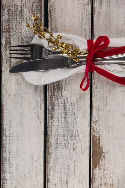 Cutlery wrapped with christmas motif on a wooden table