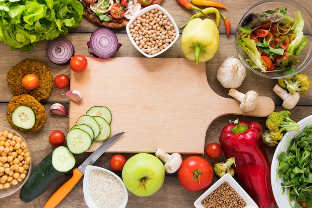 Cutting board surrounded by vegetables