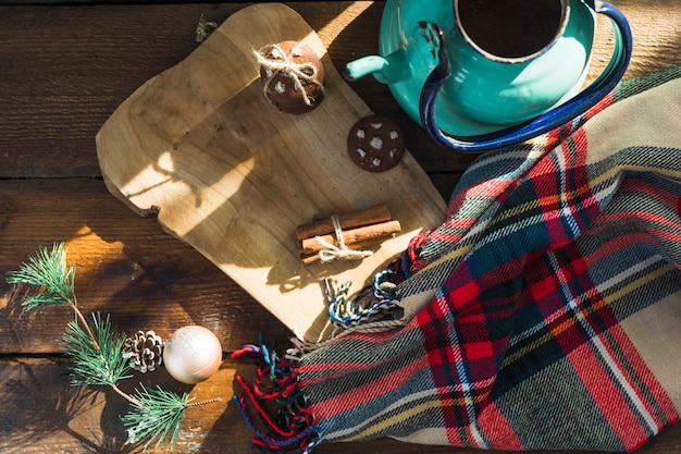 Cutting board with biscuits near scarf and kettle