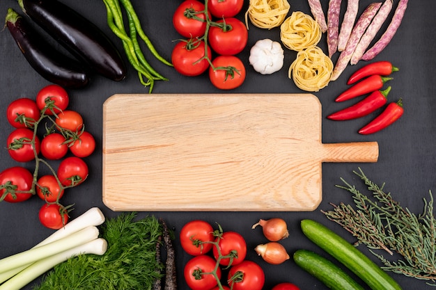 cutting board with copy space surrounded by vegetables