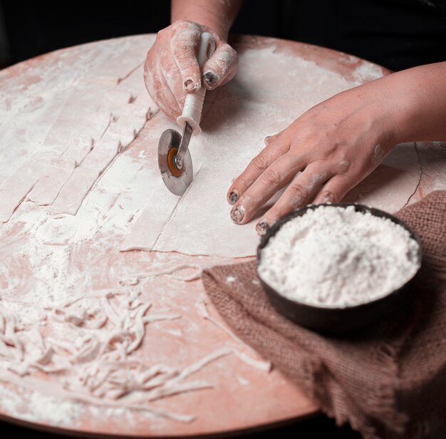 Cutting noodles from handmade layered dough.