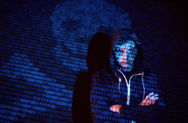 Cyber attack with unrecognizable hooded hacker using virtual reality, digital glitch effect