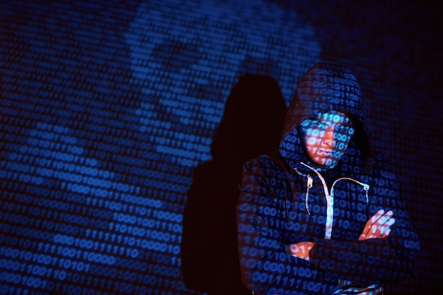 Cyber attack with unrecognizable hooded hacker using virtual reality, digital glitch effect