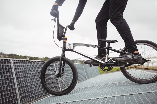 Cyclist preparing for BMX racing at starting ramp