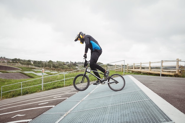 Велосипедист готовится к гонкам BMX на стартовой рампе