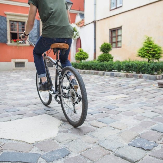 Cyclist riding bicycle on stone pavement