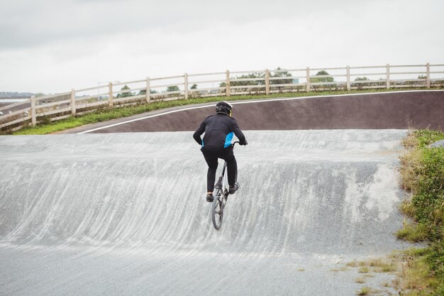 Велосипедист езда на велосипеде BMX в скейтпарк