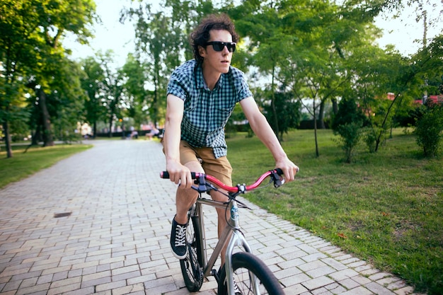 Ciclista a cavallo in un parco cittadino.