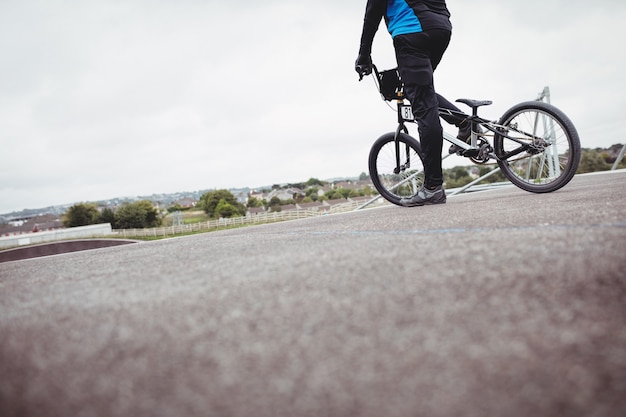 Free photo cyclist standing with bmx bike at starting ramp