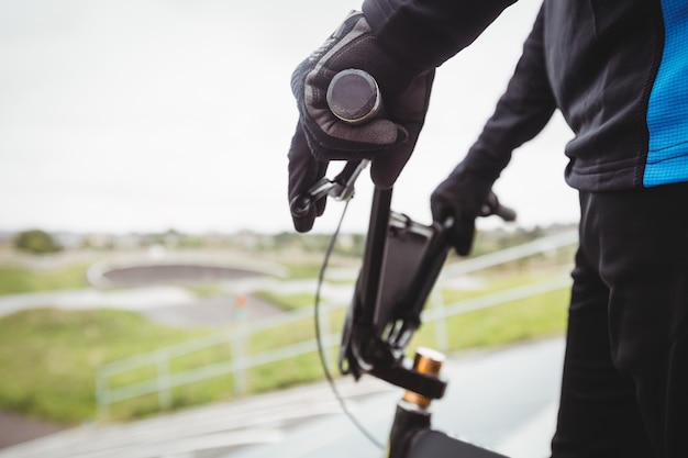 Cyclist standing with BMX bike at starting ramp