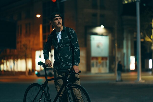 Cyclists standing on the road aside his classic bike while watch