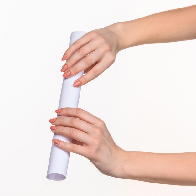 The cylinder in female hands on white wall