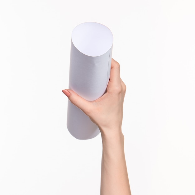 The cylinder in female hands on white wall