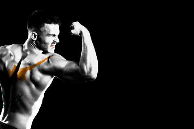 Cyprus flag on handsome young muscular man black background