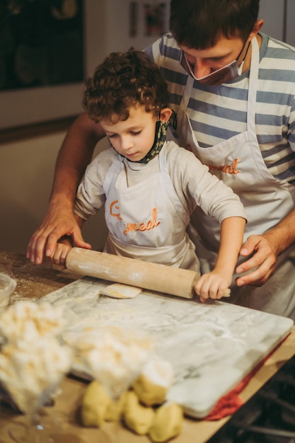 Dad and children cook pasta at a master class in gastronomy