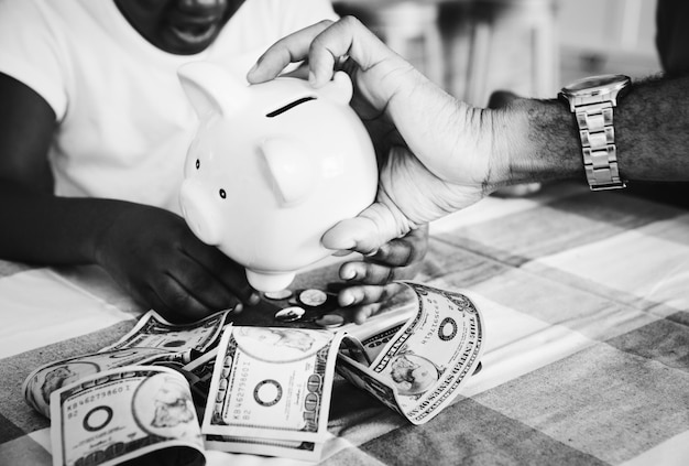 Free photo dad and daughter saving money in a piggy bank