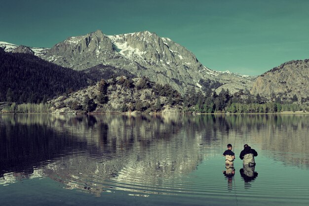 Dad fishing with son in lake in Yosemite.