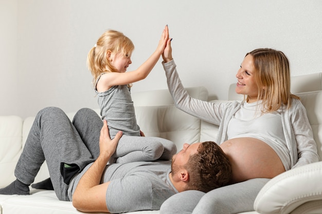 Dad holding little girl while mother plays with her