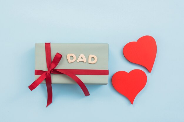 Dad inscription with gift box and hearts 