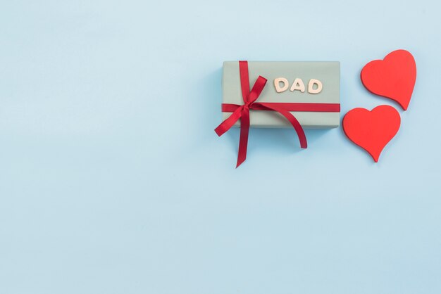 Dad inscription with gift box and red hearts 