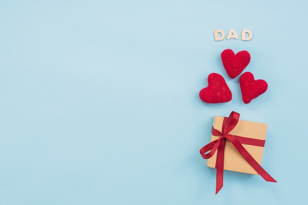 Foto gratuita iscrizione di papà con scatola regalo e cuori giocattolo