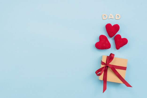 Dad inscription with gift box and toy hearts 