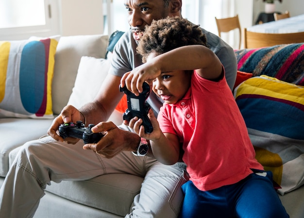 Free photo dad and son playing game at living room together