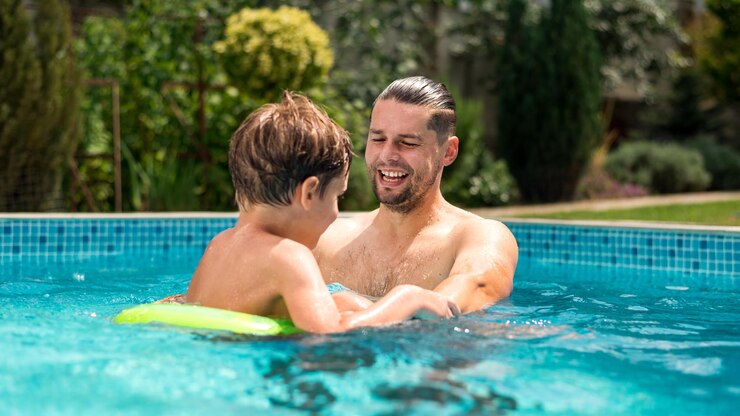 Free Photo dad swimming with his happy son in the pool