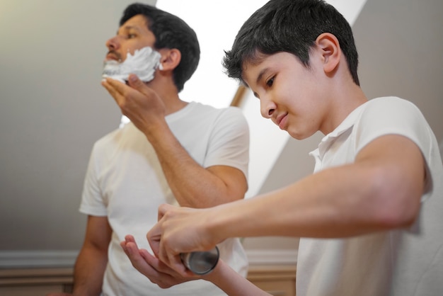 お父さんが男の子に剃る方法を教えている