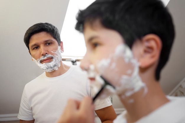 Free photo dad teaching his boy how to shave