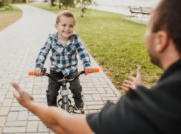 Dad teaching his child how to ride a bicycle