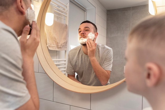 Dad teaching his son how to shave