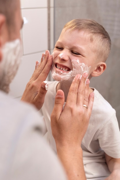 Dad teaching his son how to shave