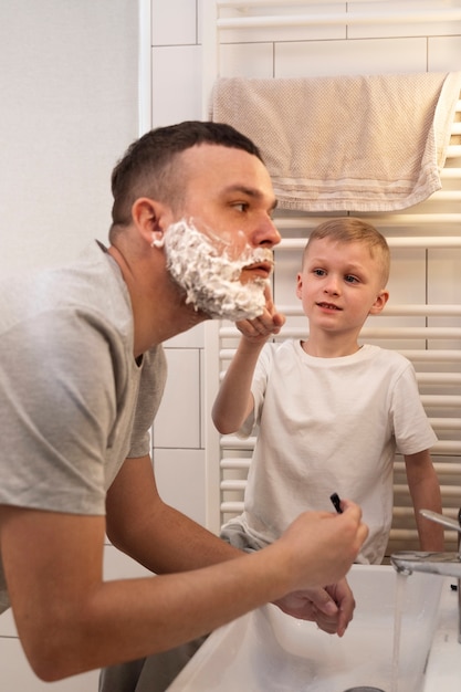 Dad teaching his son how to shave