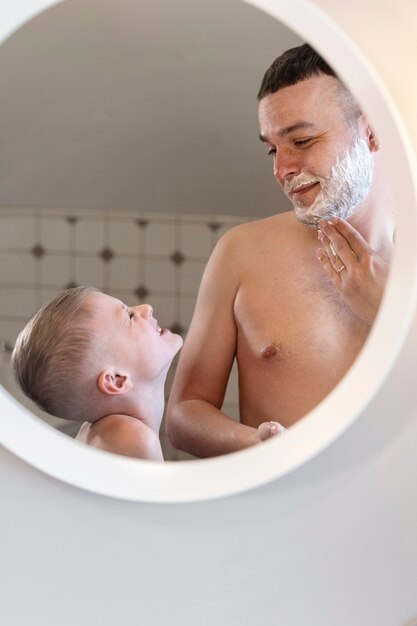 Dad teaching his son how to shave