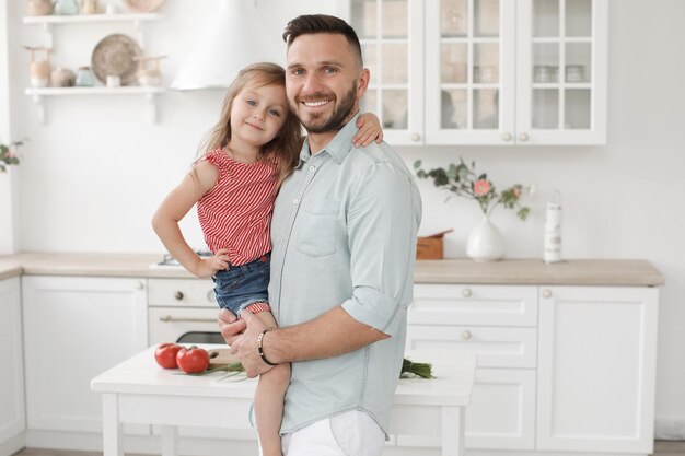 dad with cute smiling daughter indoor at kitchen