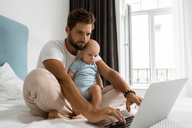 Dad working on laptop from home during quarantine with child