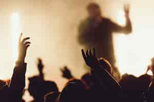 Free photo dancing at a concert while the singer is performing surrounded with lights