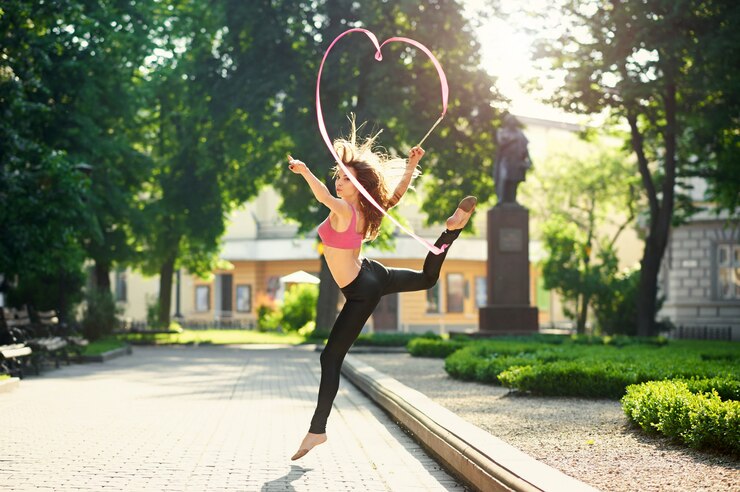 Free Photo dancing girl making pirouettes with a ribbon in the city park.