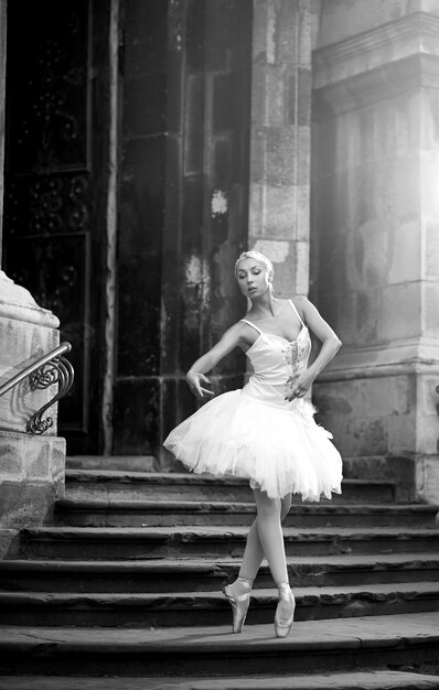 춤은 그녀의 열정입니다. 오래 된 성 흑백 소프트 포커스 근처 야외에서 포즈를 취하는 멋진 발레리나 댄서